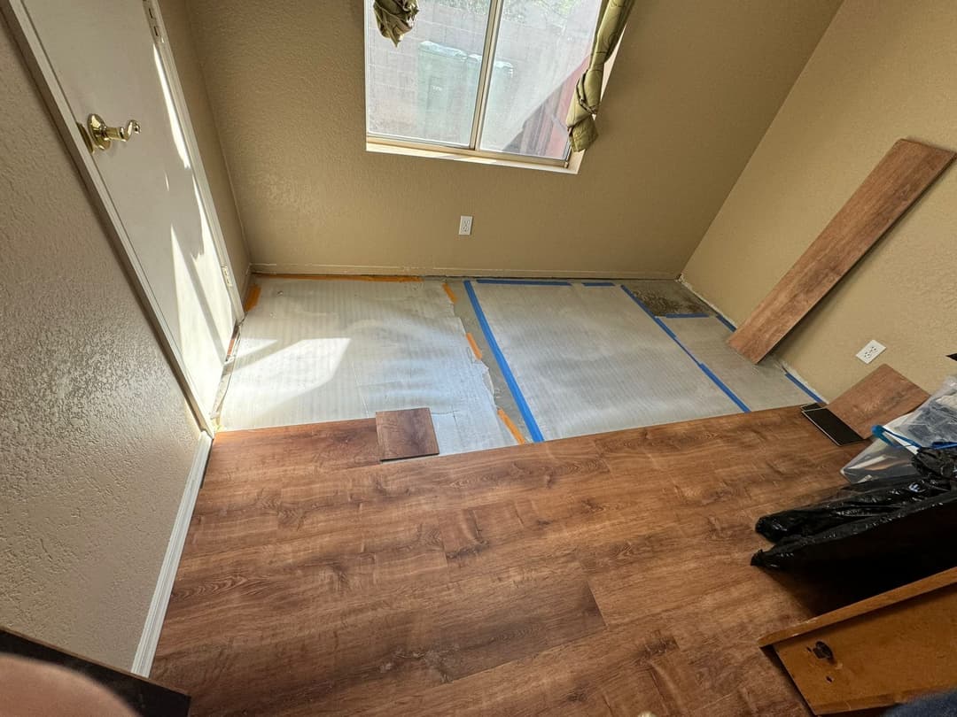 Room renovation in progress with new flooring, window, and door.